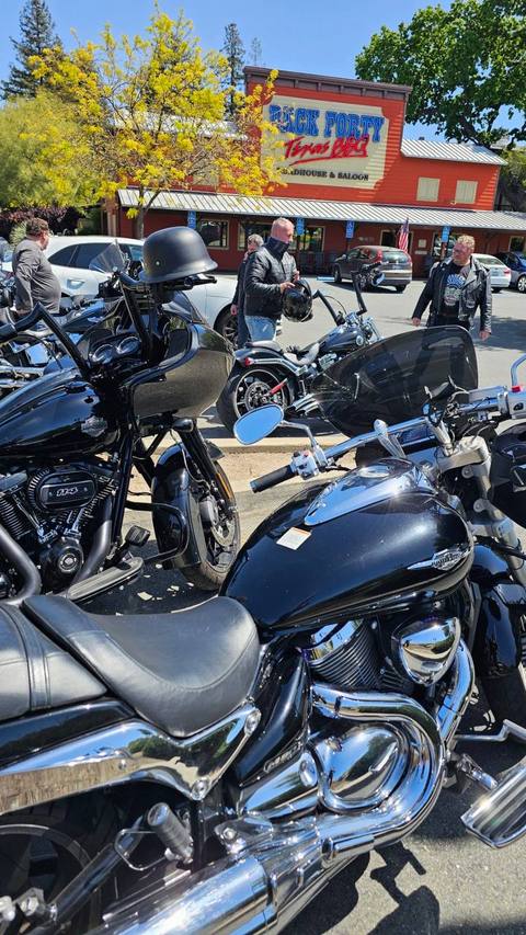 A row of motorcycles parked near a roadside building.
