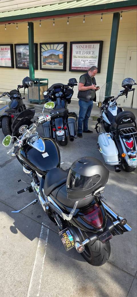 Riders standing near parked motorcycles outside a building.