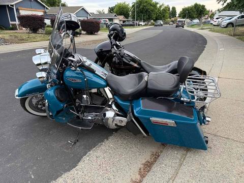 A blue touring motorcycle parked on a quiet street.