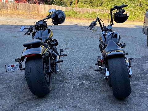 A rear view of two motorcycles parked side by side.
