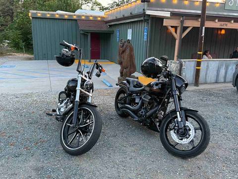Two motorcycles parked outside a rustic building.
