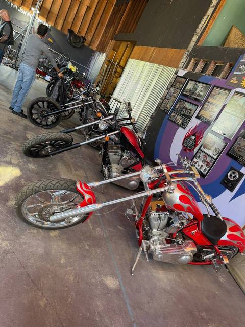 Motorcycles displayed inside a building, including a red motorcycle in front.