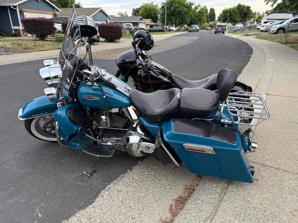 A blue touring motorcycle parked on a quiet street.