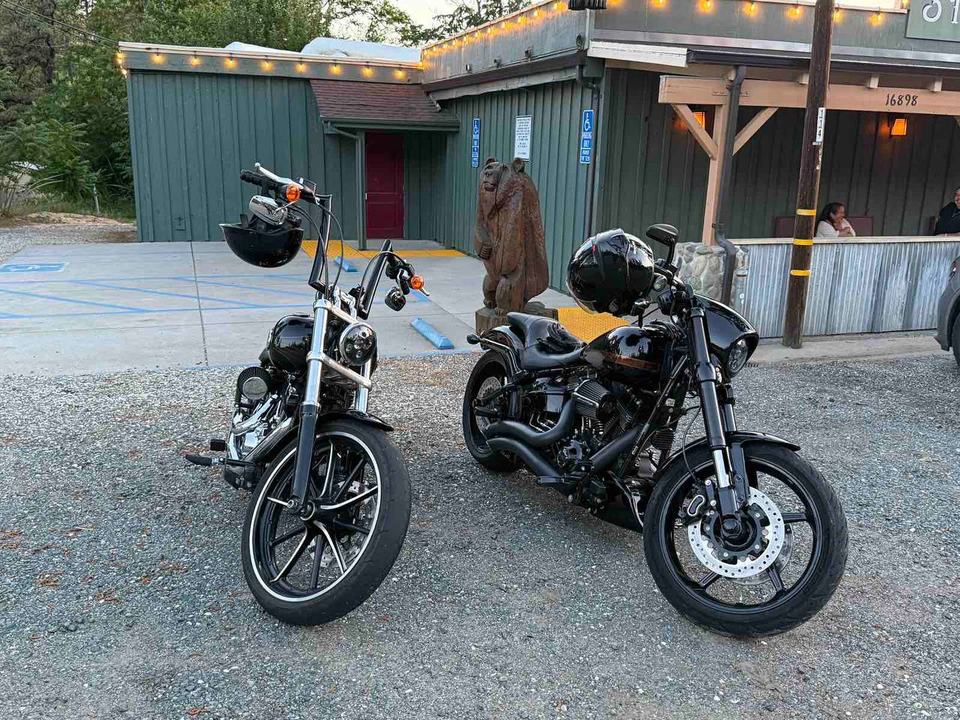 Two motorcycles parked outside a rustic building.